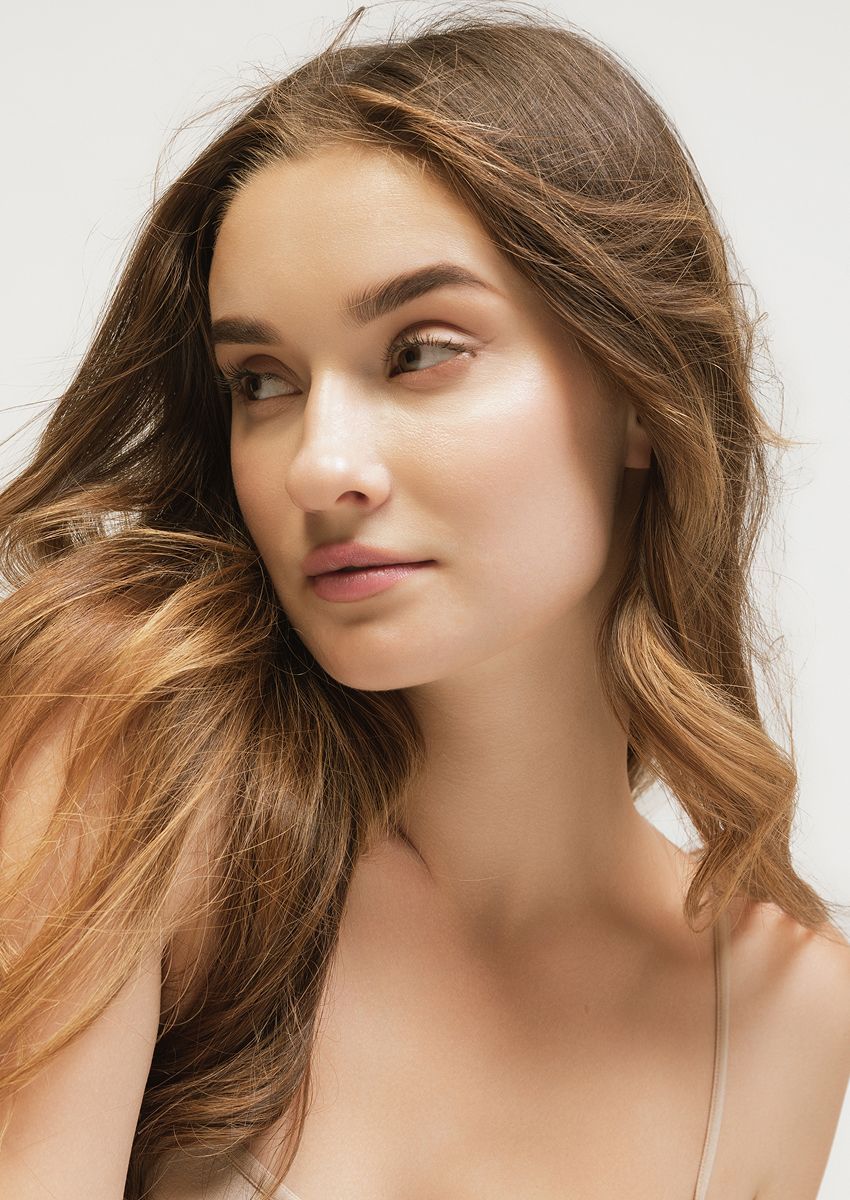 Woman with flowing hair and natural makeup.