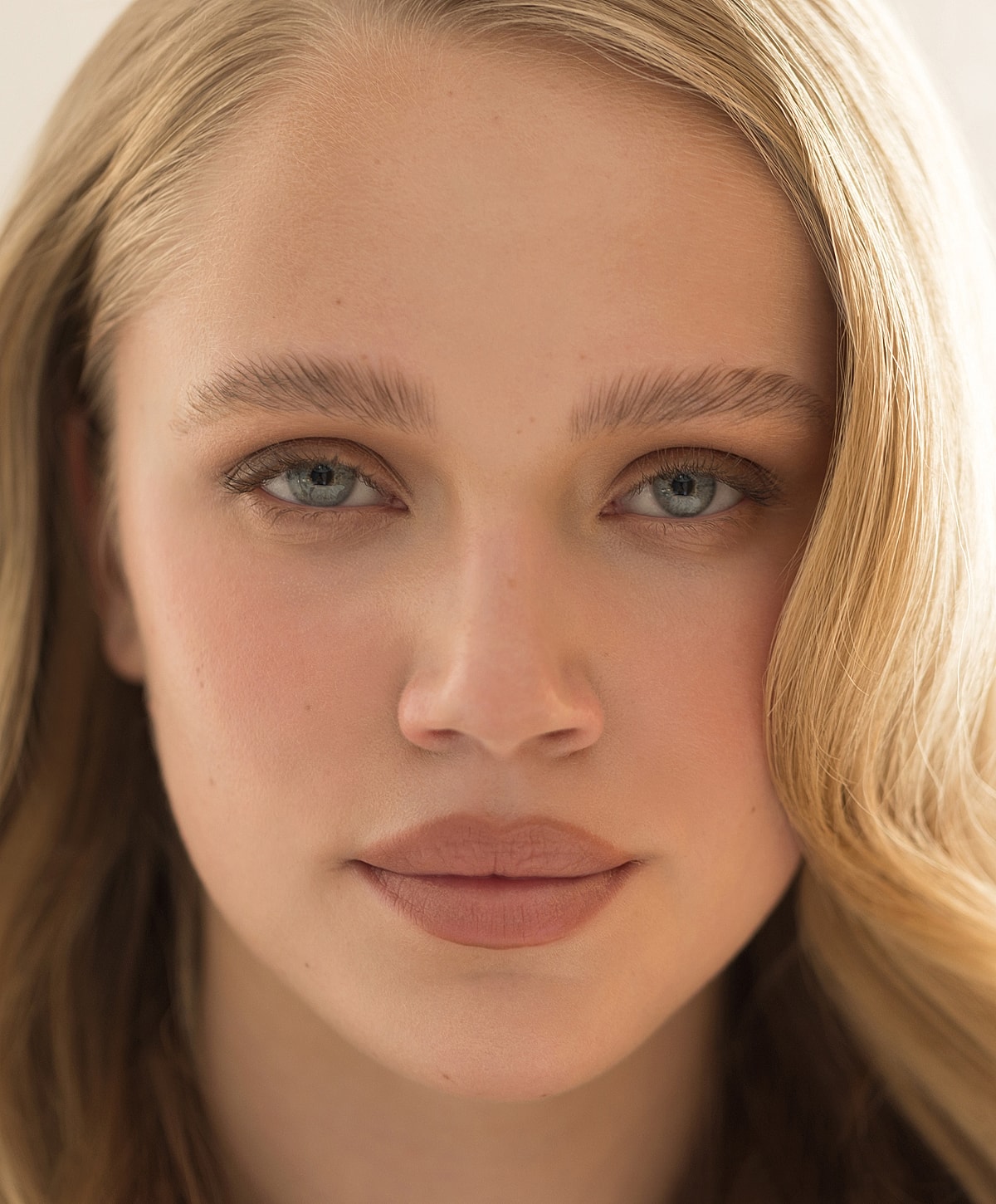 Smiling woman with blue eyes and natural makeup.