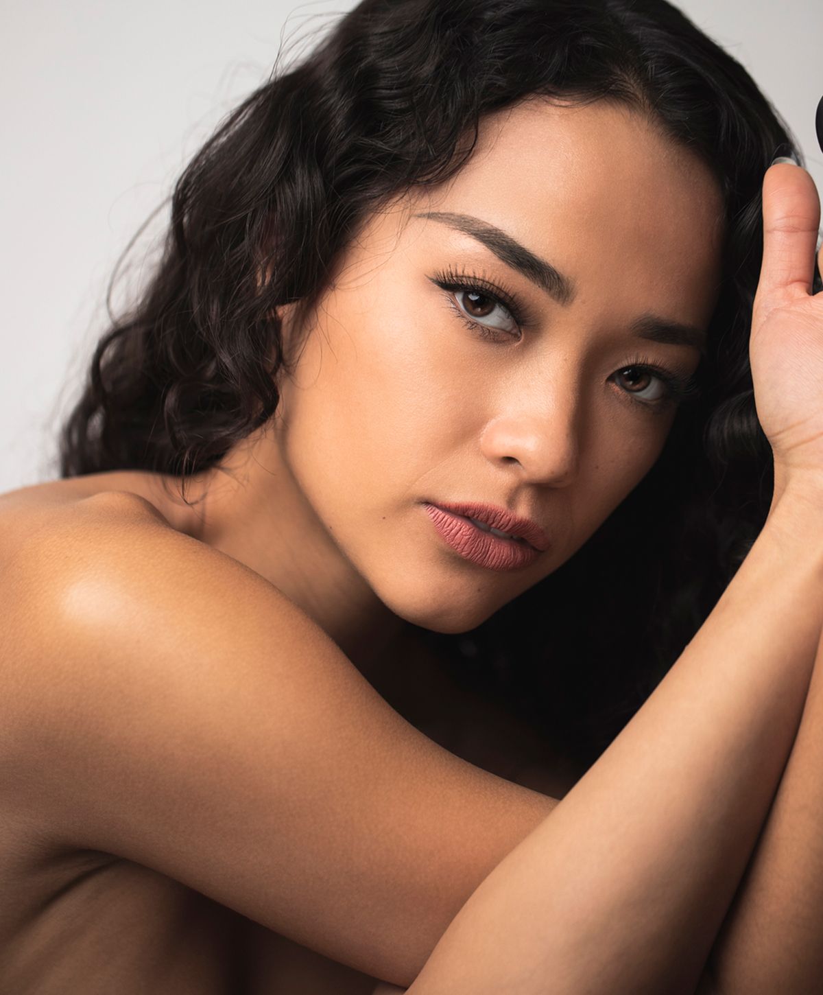 Portrait of a woman with curly hair, expressive gaze.