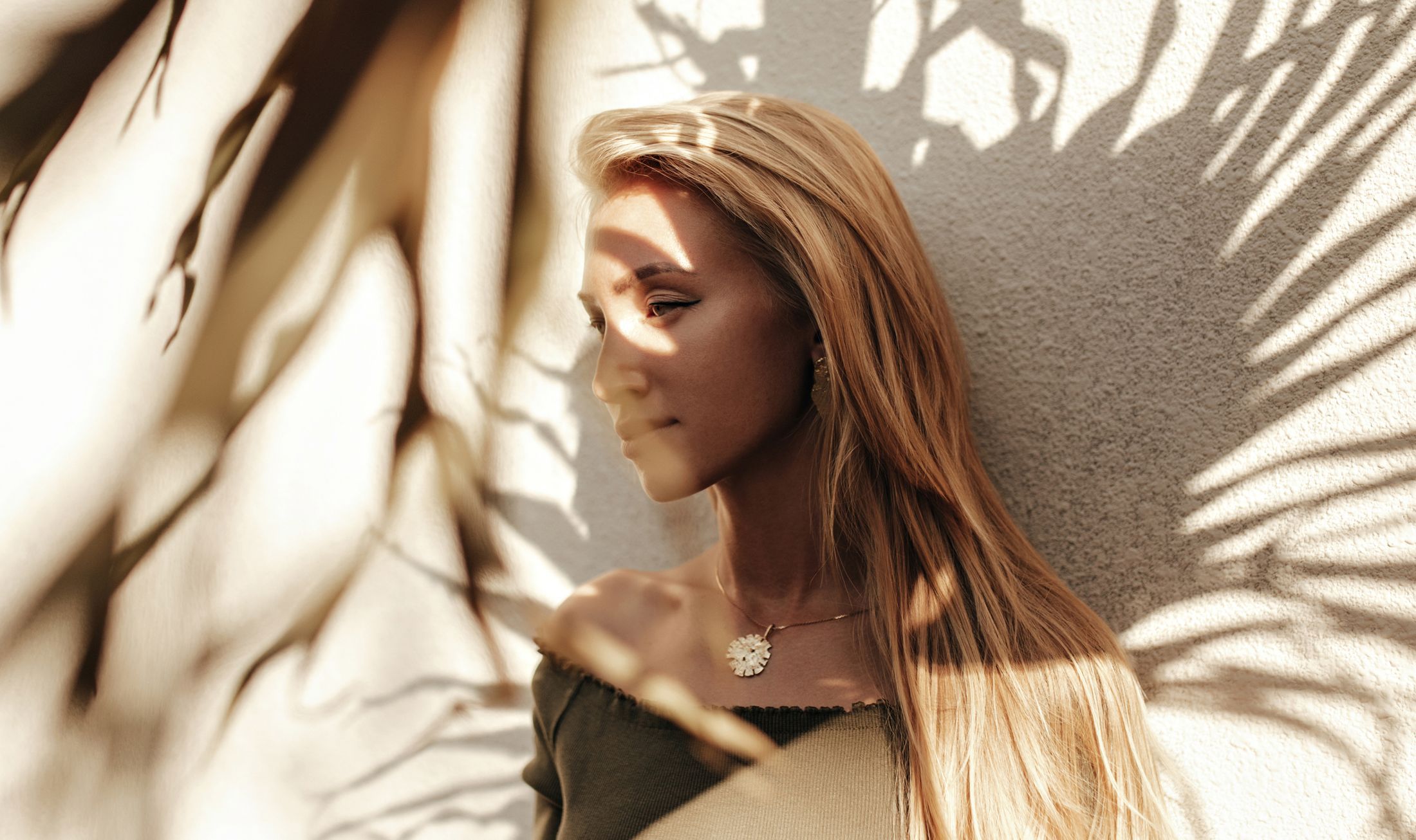 Woman with long hair against shadowy background.