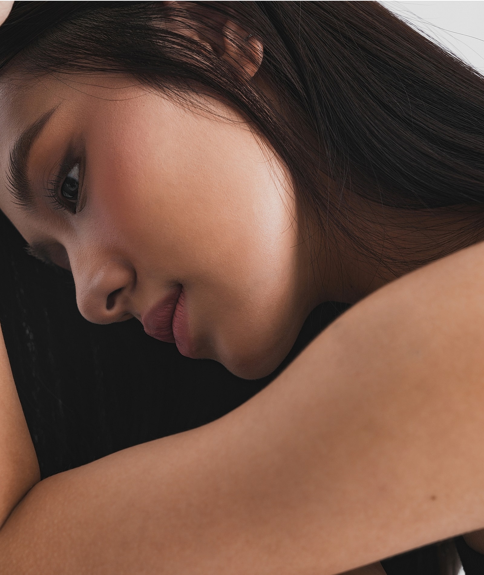 Woman in cozy robe touching her face.